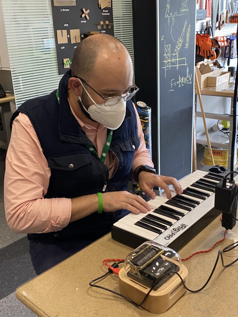 Felipe Gutiérrez Álvarez is playing programmable music box Muro Box via the MIDI keyboard in his classroom.