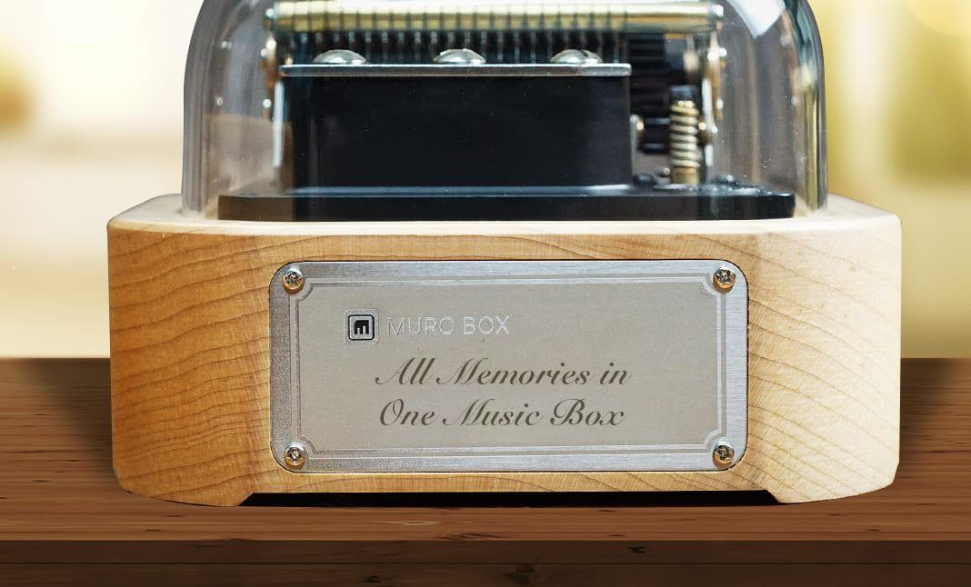 Muro Box-N20標準版的正面有一片金屬銘版，讓您自行設計圖文展示祝福的話語與具有意義的圖案。如果選擇不展示客製化雷雕設計，預設出貨狀態的金屬銘板會出現我們品牌的英文標語：All Memories in One Music Box