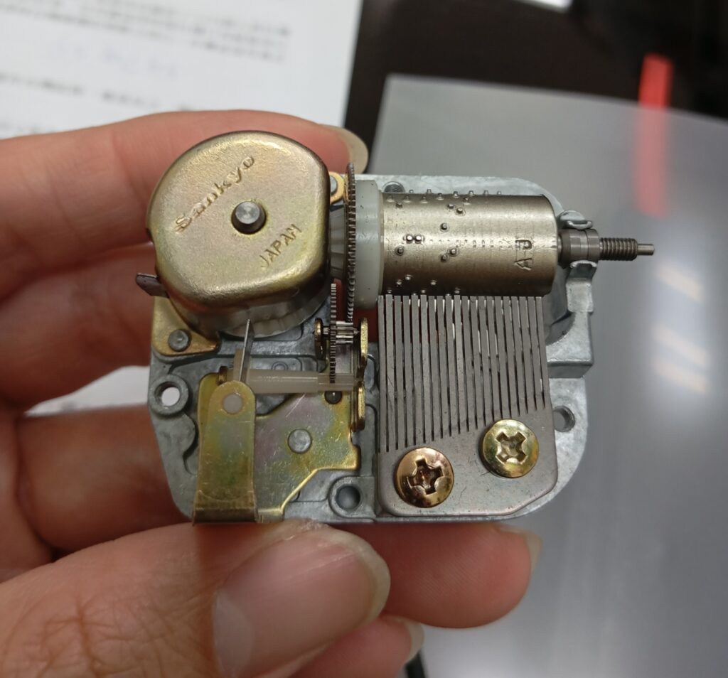 Sankyo「2S」音樂鈴機芯，金屬齒輪與片狀止速閥展現早期工藝特色。