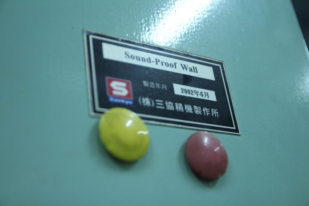 協櫻隔音牆上的銘板，展示協櫻「S」標誌與三協精機製作所（Sankyo）字樣，象徵其作為 Sankyo 在台灣的技術授權工廠。