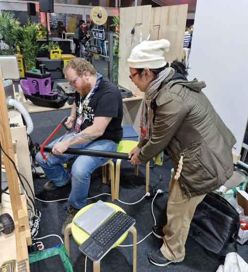 我扶著大膠管，等鄰座展攤IncubhackerASBL 的Maker幫我切割的裝海報帶回台灣用的膠管。