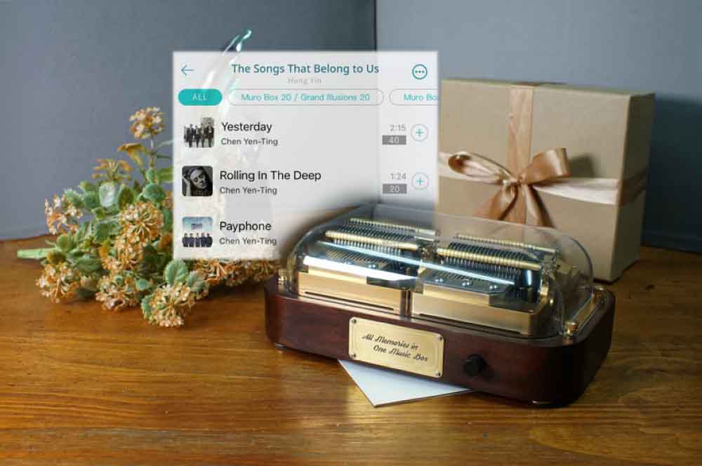 Custom music box gift guide: From choosing the Muro Box programmable music box or paper-strip music box to arranging the melody. Items in the image include: Muro Box-N40 Sublime programmable music box, gift box, and a screenshot of the Muro Box App’s music library playlist.